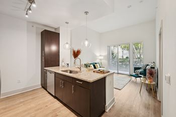 A kitchen with brown cabinets and a marble countertop.